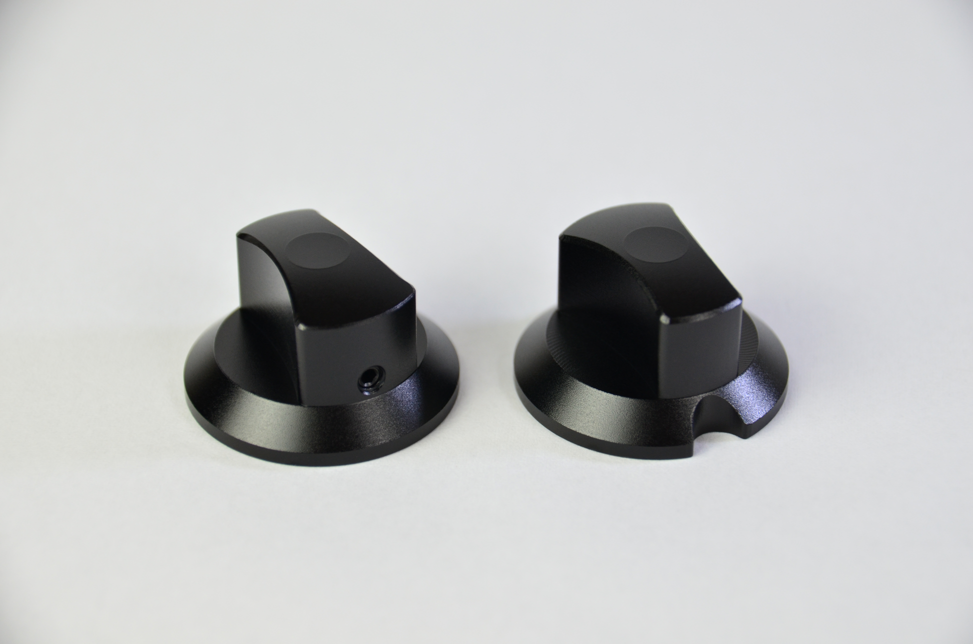 Two black anodized aluminium rotary knobs for sim racing DIY project.