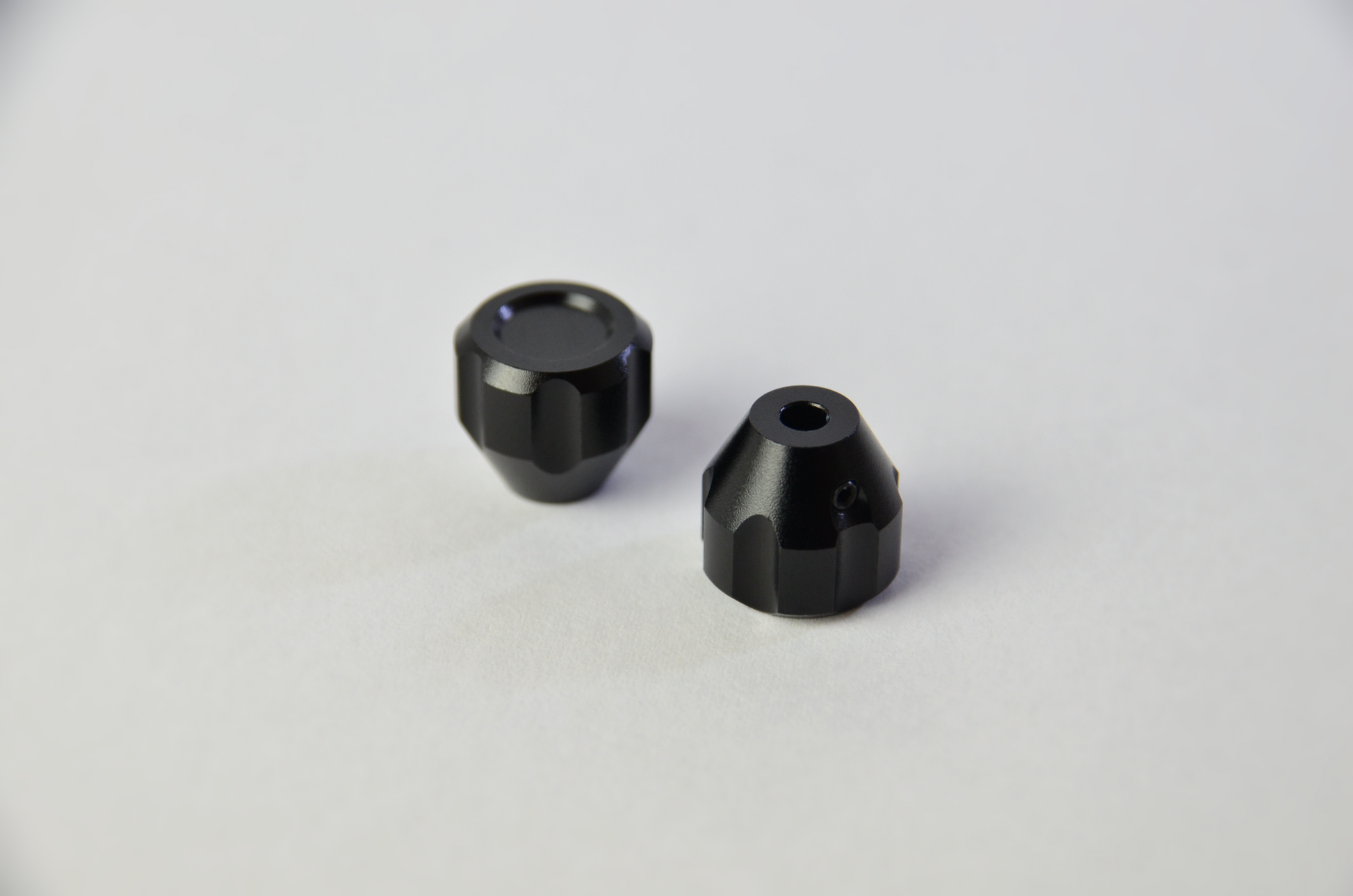 Two black anodized aluminium switch knobs for sim racing DIY projects. Front view.