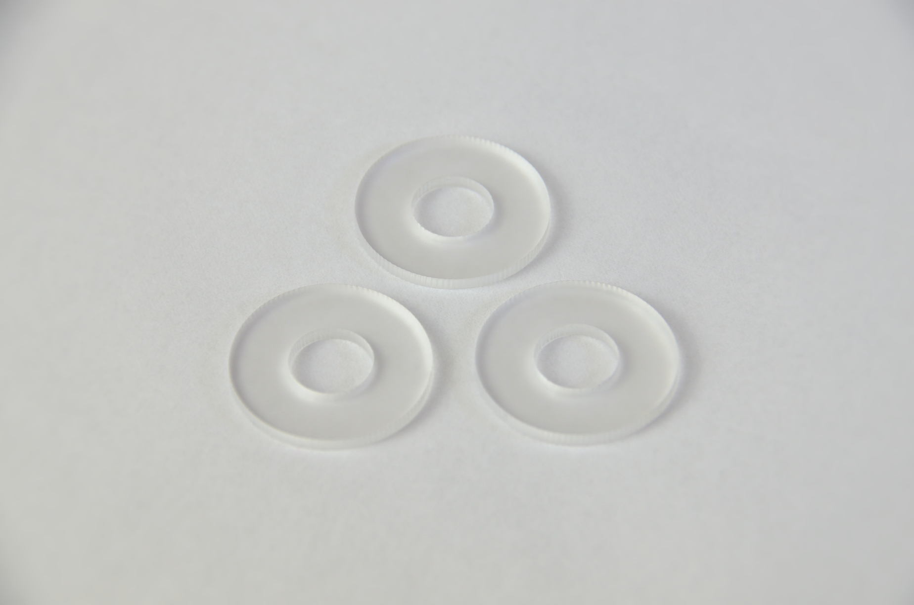 Three frosted plexiglass diffusers arranged in a triangular formation on a white background.