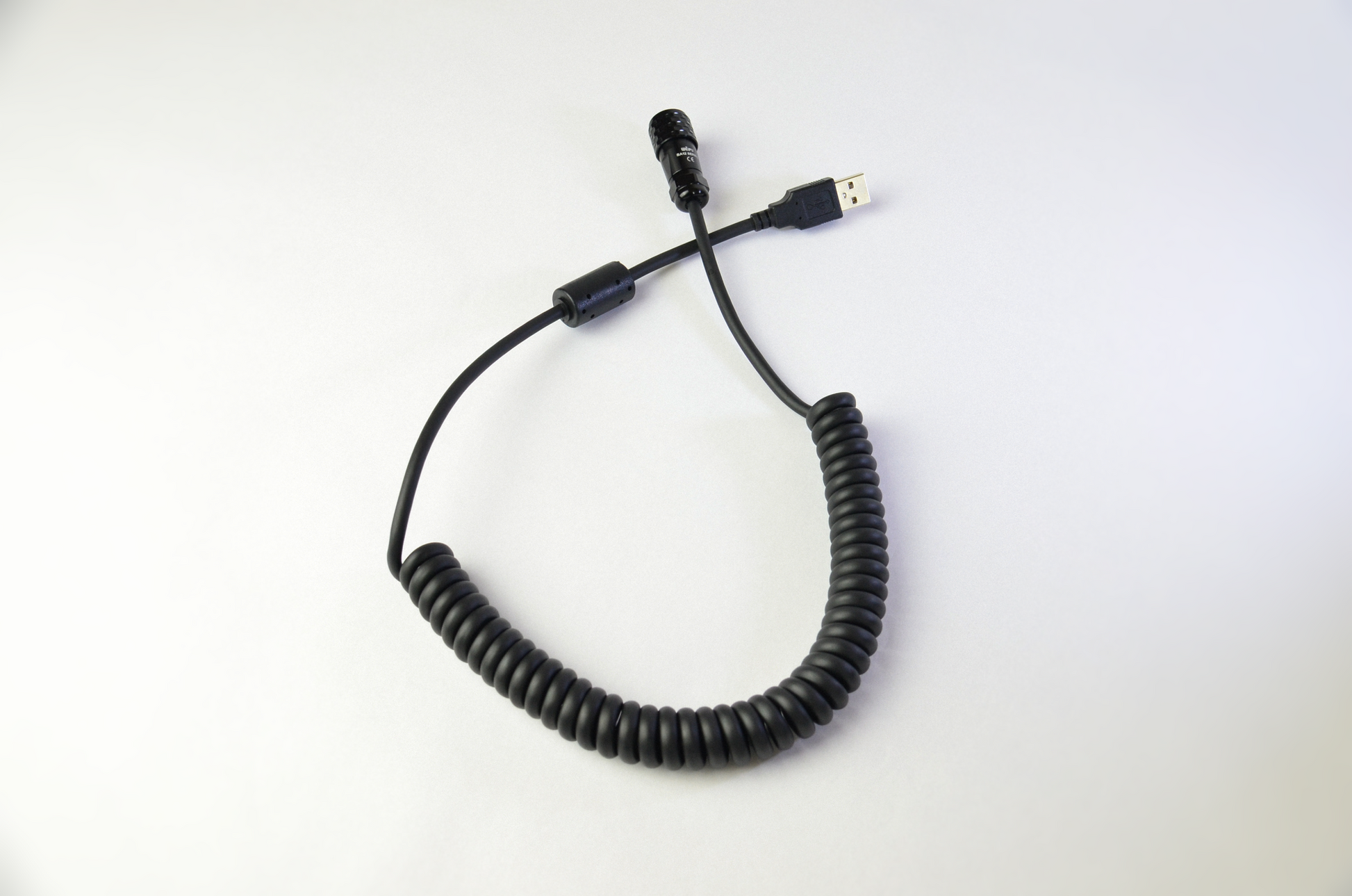 A black USB coiled cable with a USB A connector on one end and a Weipu SA12 connector on the other, on a white background.